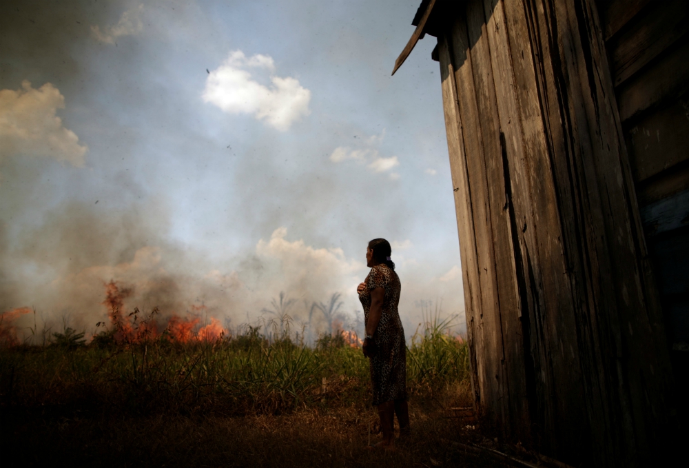 Miraceli de Oliveira reacts as fire approaches her house in an area of the Amazon rainforest near Porto Velho, Brazil, Aug. 16. (CNS/Reuters/Ueslei Marcelino) Miraceli de Oliveira reacts as fire approaches her house in an area of the Amazon rainforest near Porto Velho, Brazil, Aug. 16. (CNS/Reuters/Ueslei Marcelino)