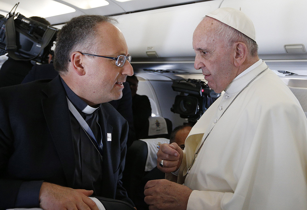 Pope Francis is pictured in a file photo talking with Fr. Antonio Spadaro, editor of La Civilta Cattolica, aboard his flight from Rome to Krakow, Poland. (CNS/Paul Haring)