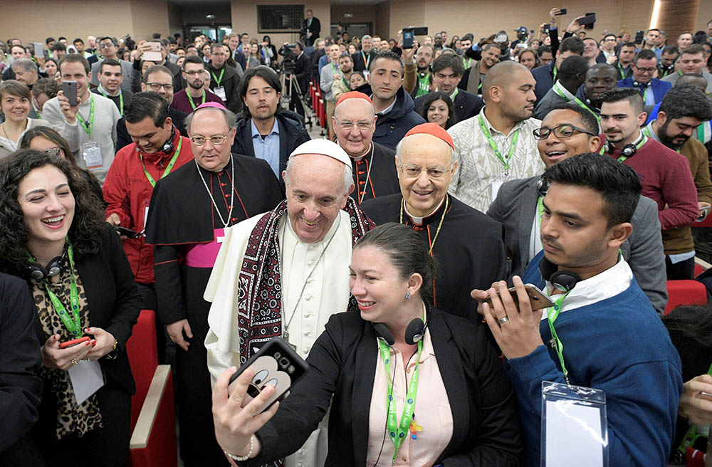 Pope Francis poses for a selfie during a gathering of youth delegates at the Pontifical International Maria Mater Ecclesiae College in Rome, ahead of the Synod of Bishops on young people in 2018. (CNS/Vatican Media)
