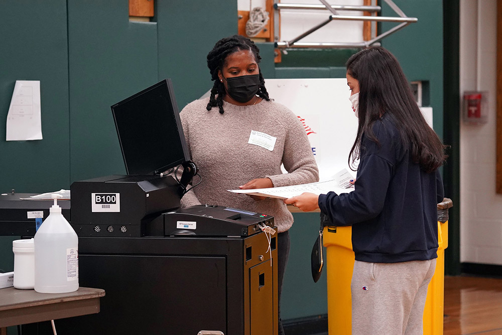 A poll worker looks on as a voter casts her ballot on Election Day Nov. 3, 2020, at William S. Mount Elementary School in Stony Brook, New York. (CNS/Gregory A. Shemitz)