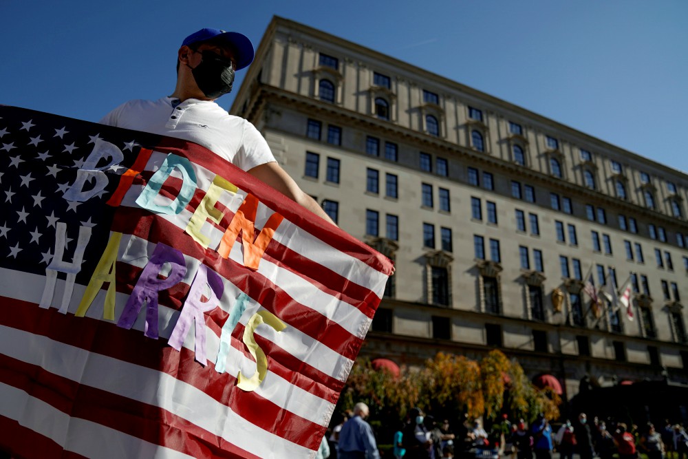 A man in Washington waves an American flag with the words "Biden Harris" near the White House Nov. 8, the day after the news media called the presidential election for Democrat Joe Biden. (CNS/Reuters/Erin Scott) A man in Washington waves an American flag with the words "Biden Harris" near the White House Nov. 8, the day after the news media called the presidential election for Democrat Joe Biden. (CNS/Reuters/Erin Scott)