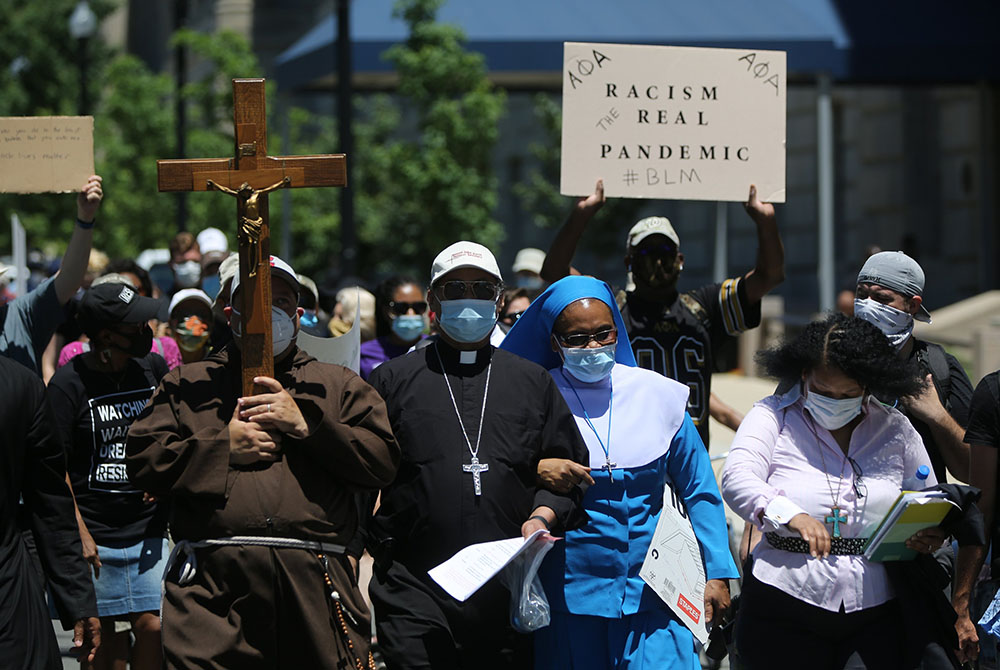 Washington Auxiliary Bishop Roy E. Campbell and a woman religious walk with others toward the National Museum of African American History and Culture in Washington during a peaceful protest June 8, 2020, following the death of George Floyd, an unarmed Bla