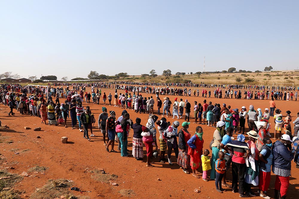 People in Laudium, South Africa, stand in line to receive food aid May 20, 2020, amid the COVID-19 pandemic. (CNS/Reuters/Siphiwe Sibeko)