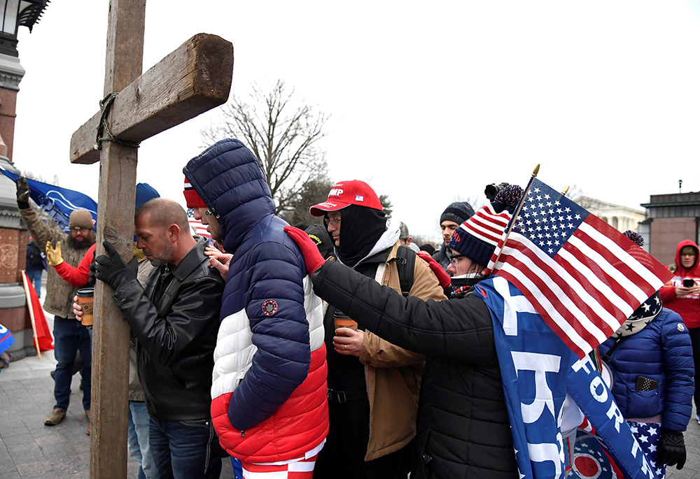 Supporters of then-President Donald Trump join in prayer outside the U.S. Capitol Jan. 6, 2021, in Washington, where Congress was to meet in joint session to certify the Electoral College vote for then-President-elect Joe Biden. (CNS/Reuters/Mike Theiler)