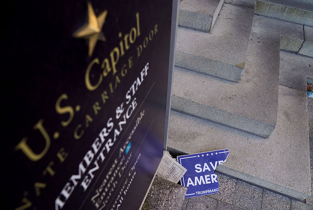 Scraps of a demonstrator's poster lays near the Senate Carriage Entrance of the U.S. Capitol in Washington Jan. 7, 2021, a day after hundreds of supporters of President Donald Trump occupied the Capitol. (CNS/Erin Scott, Reuters)