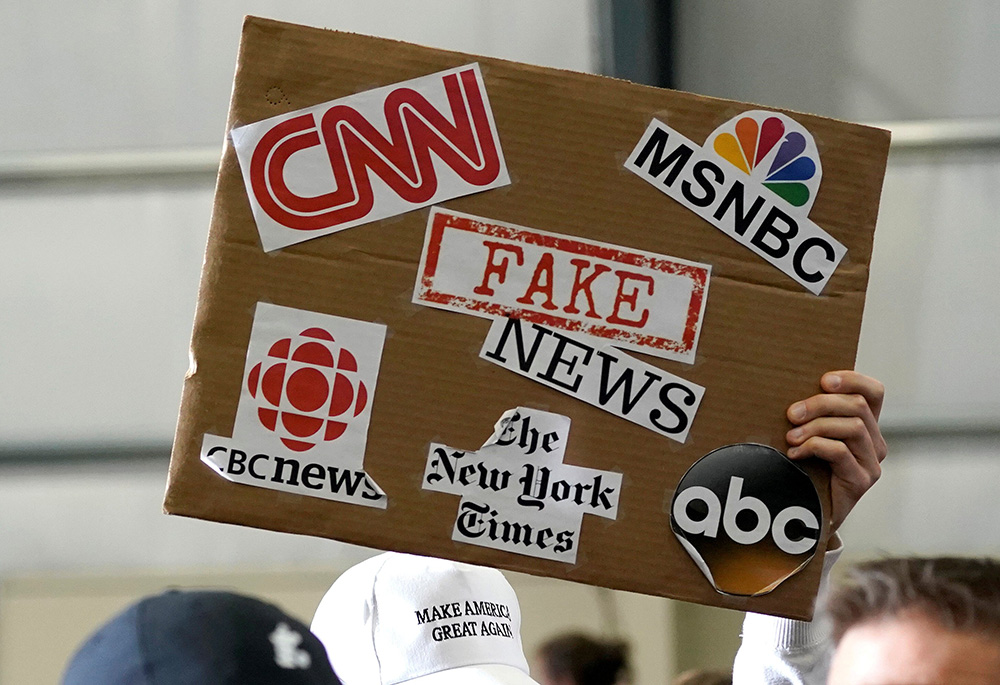 A sign showing major news organizations along with the words "fake news" is held up as then-U.S. President Donald Trump speaks at a rally in Washington, Michigan April 28, 2018. (CNS/Reuters/Joshua Roberts) A sign showing major news organizations along with the words "fake news" is held up as then-U.S. President Donald Trump speaks at a rally in Washington, Michigan April 28, 2018. (CNS/Reuters/Joshua Roberts)