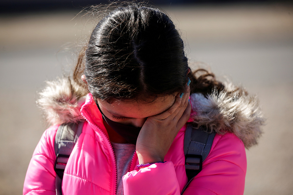 A migrant girl from Central America cries before crossing the Rio Bravo with her family in Ciudad Juárez, Mexico, Feb. 5 to request asylum in El Paso, Texas. (CNS/Reuters/Jose Luis Gonzalez)