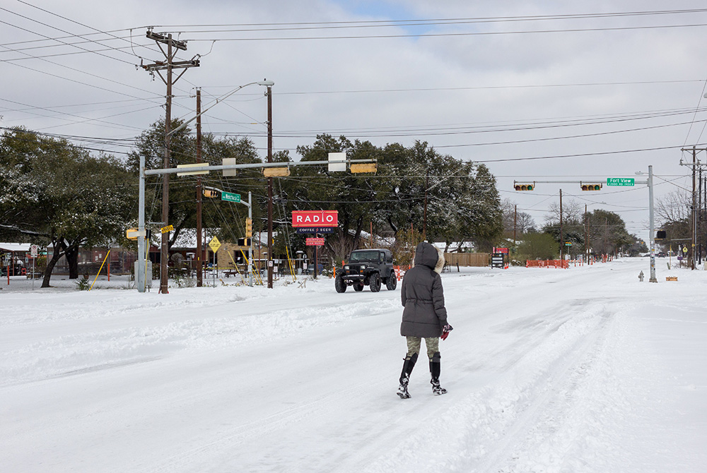 : Stranded without power, a resident walks along a snow-covered road Feb. 16 in Austin, Texas. A failed attempt to provide "rotating blackouts" during Texas' historic winter storm left at least nearly 200,000 people without power in single-digits temperat : Stranded without power, a resident walks along a snow-covered road Feb. 16 in Austin, Texas. A failed attempt to provide "rotating blackouts" during Texas' historic winter storm left at least nearly 200,000 people without power in single-digits temperat