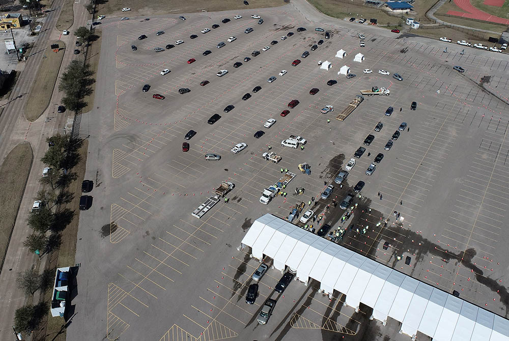Cars line up to receive free cases of water at Delmar Stadium Feb. 19 in Houston, after the city implemented a boil water advisory following an unprecedented winter storm. (CNS/Drone Base via Reuters)