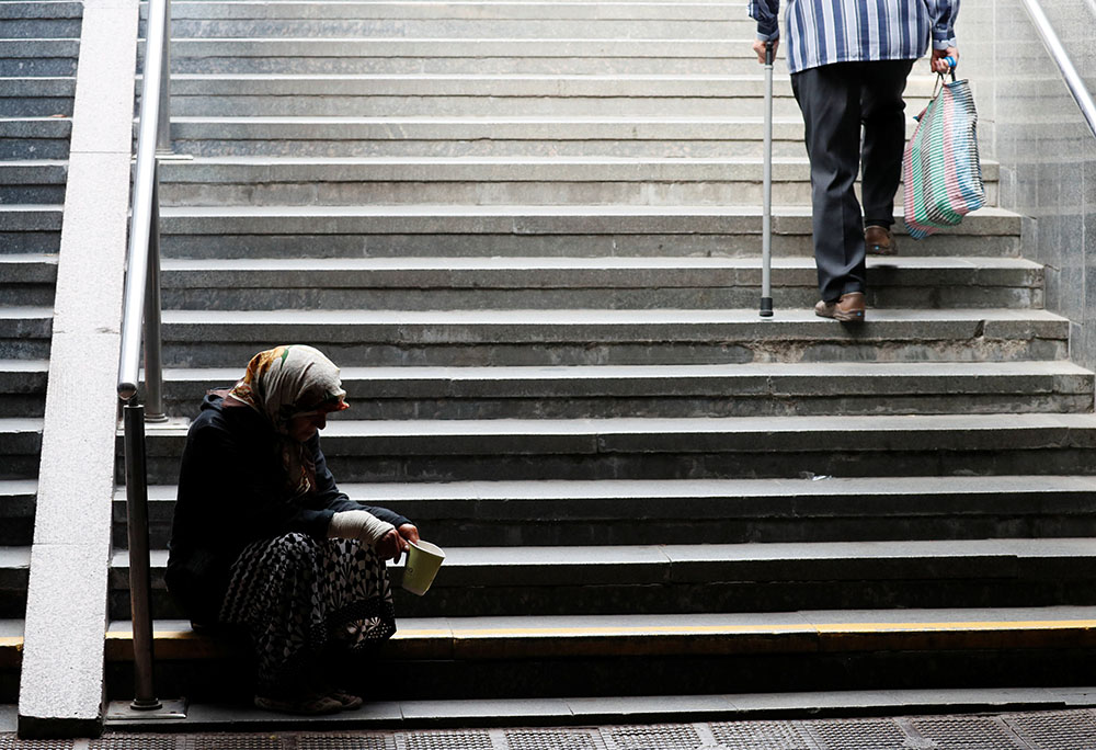 An elderly woman in Kyiv, Ukraine, begs for money in an underpass Sept. 11, 2020, amid the coronavirus pandemic. (CNS/Reuters/Gleb Garanich)