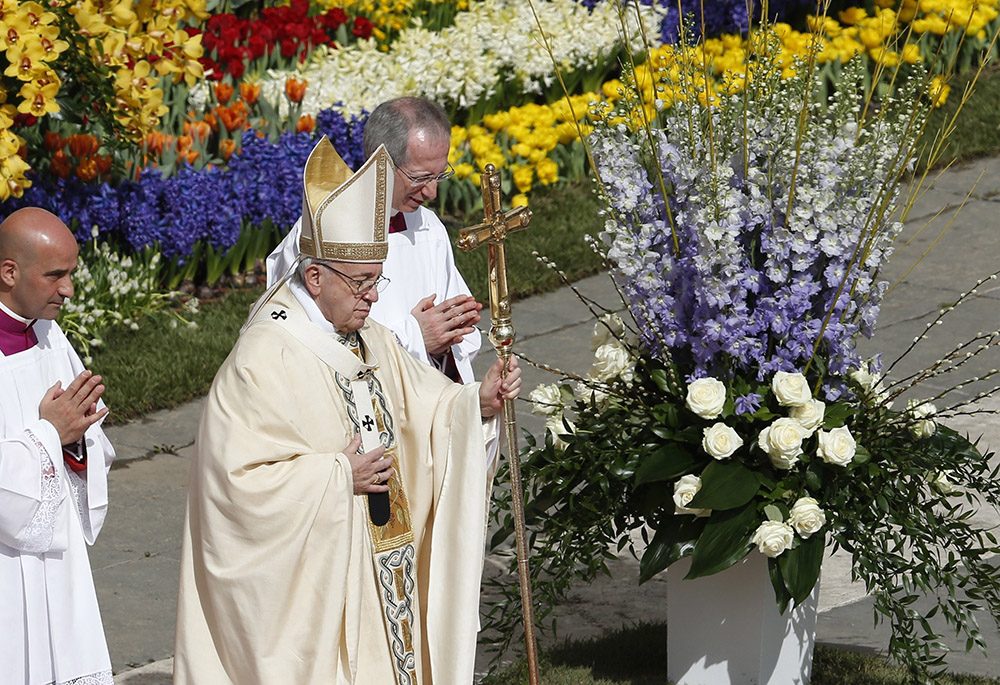 Pope Francis walks past flowers as he celebrates Easter Mass in St. Peter's Square at the Vatican in this April 1, 2018, file photo. (CNS/Paul Haring)