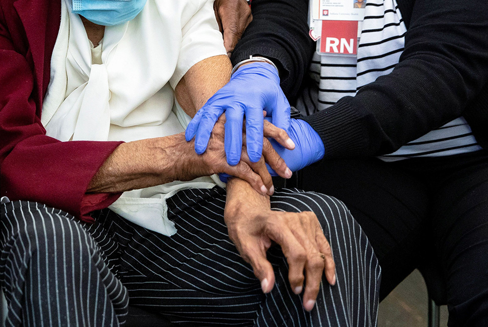 A 111-year-old woman is comforted by a nurse following her COVID-19 vaccination at IU Health Neuroscience Center March 16 in Indianapolis. (CNS/Chris Bergin, Reuters)