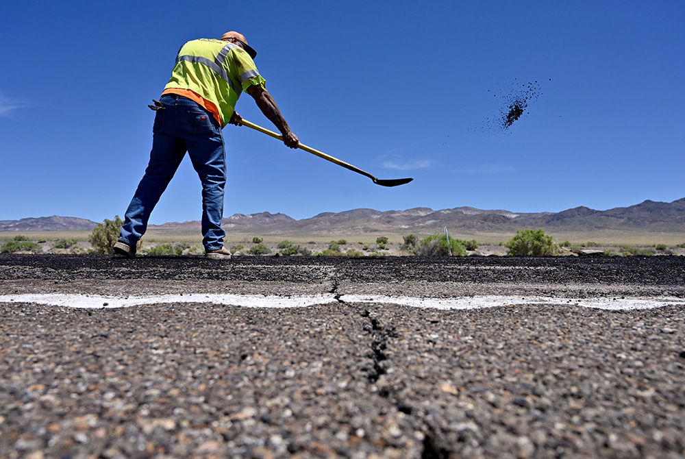 A Nevada Department of Transportation worker repairs damage to Highway 95 near Tonopah, Nevada, May 15, 2020. President Joe Biden's American Jobs Plan calls for investing more than $2 trillion over the next decade in upgrading the nation's roads, bridges,