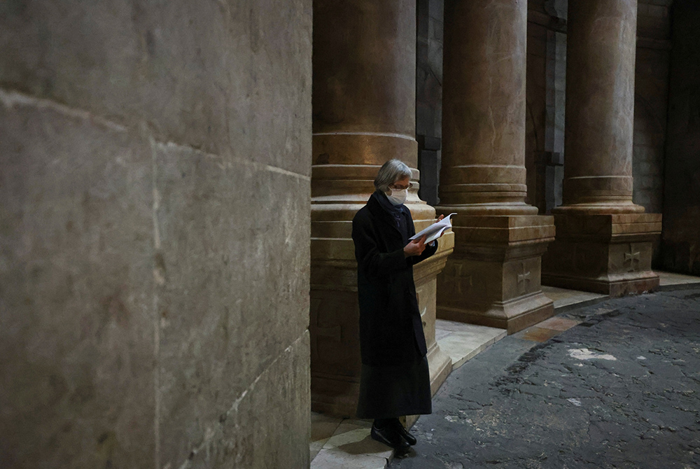 A worshipper wears a face mask to prevent the spread of COVID-19 on Holy Thursday in the Church of the Holy Sepulcher in Jerusalem's Old City April 1. This year, Joan Chittister celebrated Palm Sunday in a monastery still under a form of COVID-19 lockdown