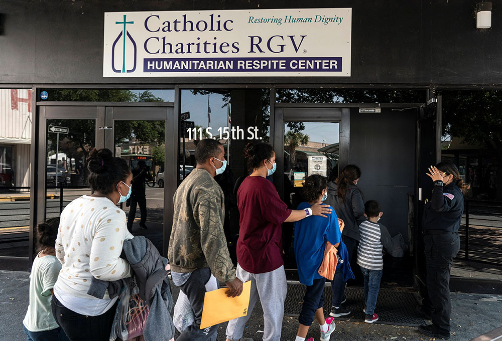 Migrants seeking asylum in the U.S. walk into a temporary humanitarian respite center run by Catholic Charities of the Rio Grande Valley in McAllen, Texas, April 8. (CNS/Reuters/Go Nakamura)