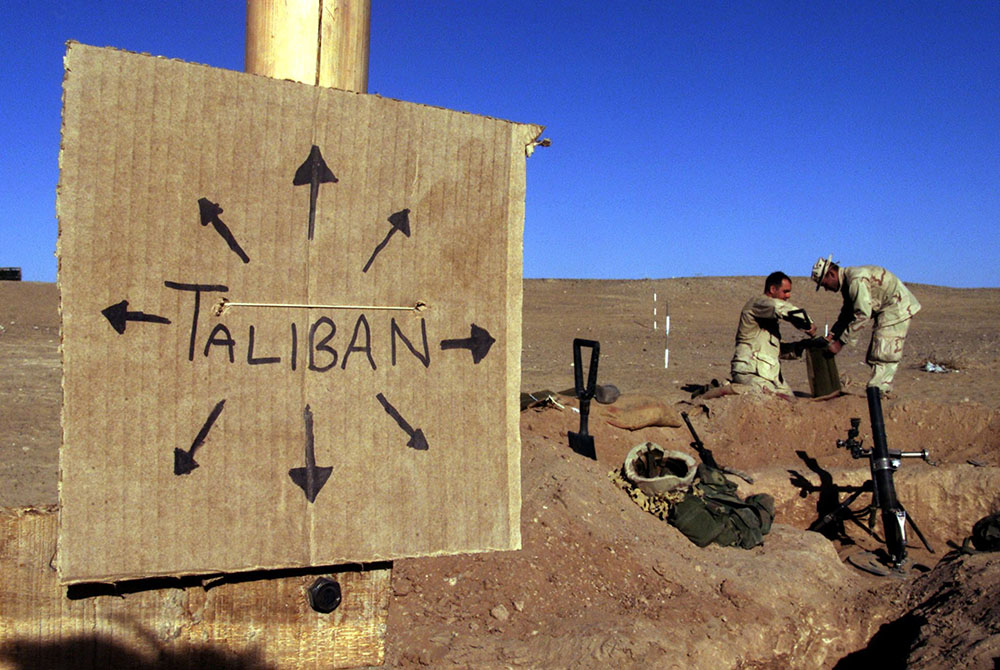 Marines from Charlie 1/1 of the 15th Marine Expeditionary Unit in southern Afghanistan fill sandbags around their light mortar position on the front lines of a Marine Corps base Dec. 1, 2001. (CNS/Reuters/Jim Hollander)