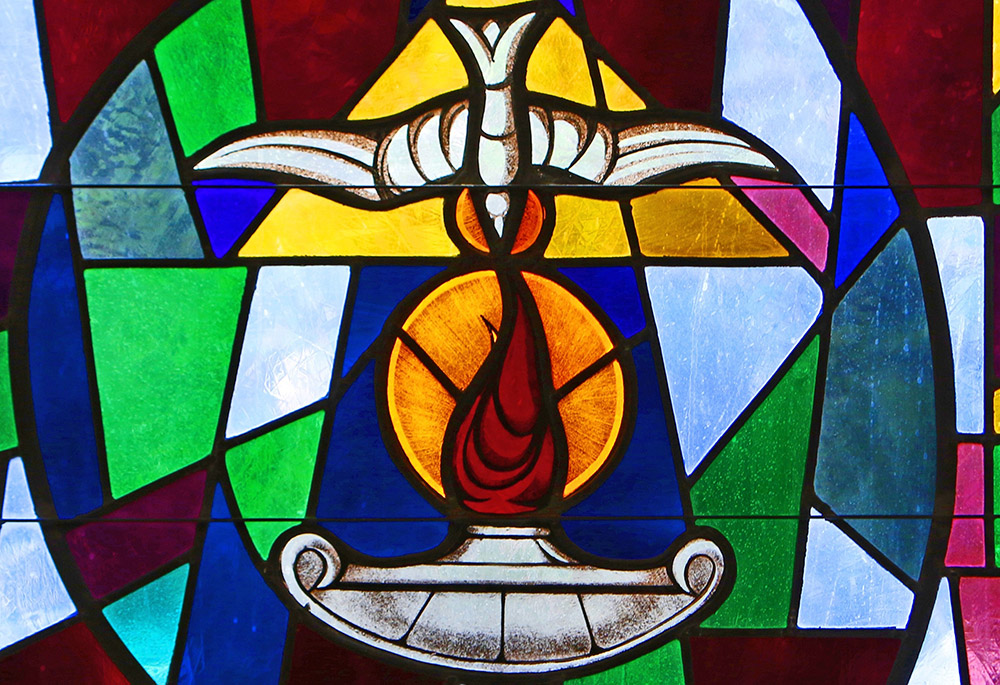 The Holy Spirit and a lantern flame symbolizing the sacrament of confirmation are depicted in a stained-glass window at Sts. Cyril & Methodius Church in Deer Park, New York. (CNS/Gregory A. Shemitz)