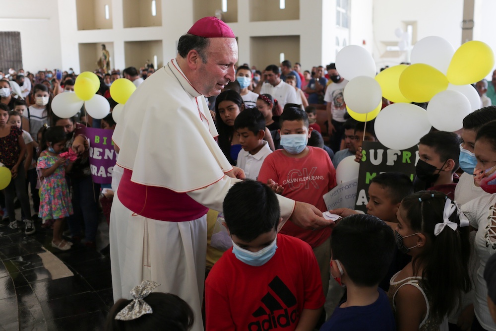 Archbishop Franco Coppola, the apostolic nuncio to Mexico, gives a rosary to a child during a visit to Aguililla April 23. Drug cartels have battled each other and blocked highways in the besieged town, leaving residents unable to travel freely and causin