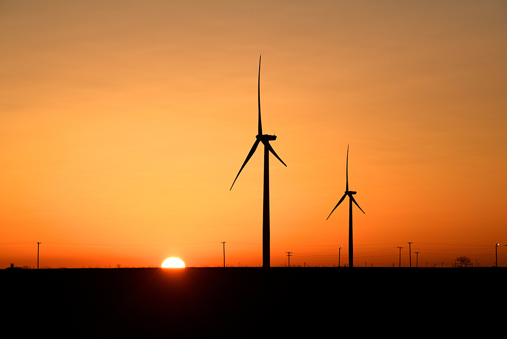 Wind turbines operate at sunrise in the Permian Basin oil and natural gas production area in Big Spring, Texas, Feb. 12, 2019. The message of Pope Francis' encyclical, "Laudato Si', on Care for Our Common Home," continues to be prophetic for a pandemic-hi