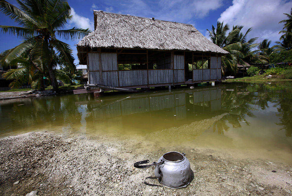 An abandoned house that is affected by seawater during high tides stands next to a small lagoon near the village of Tangintebu on South Tarawa in the central Pacific island nation of Kiribati May 25, 2013. Pope Francis said island nations need protection 