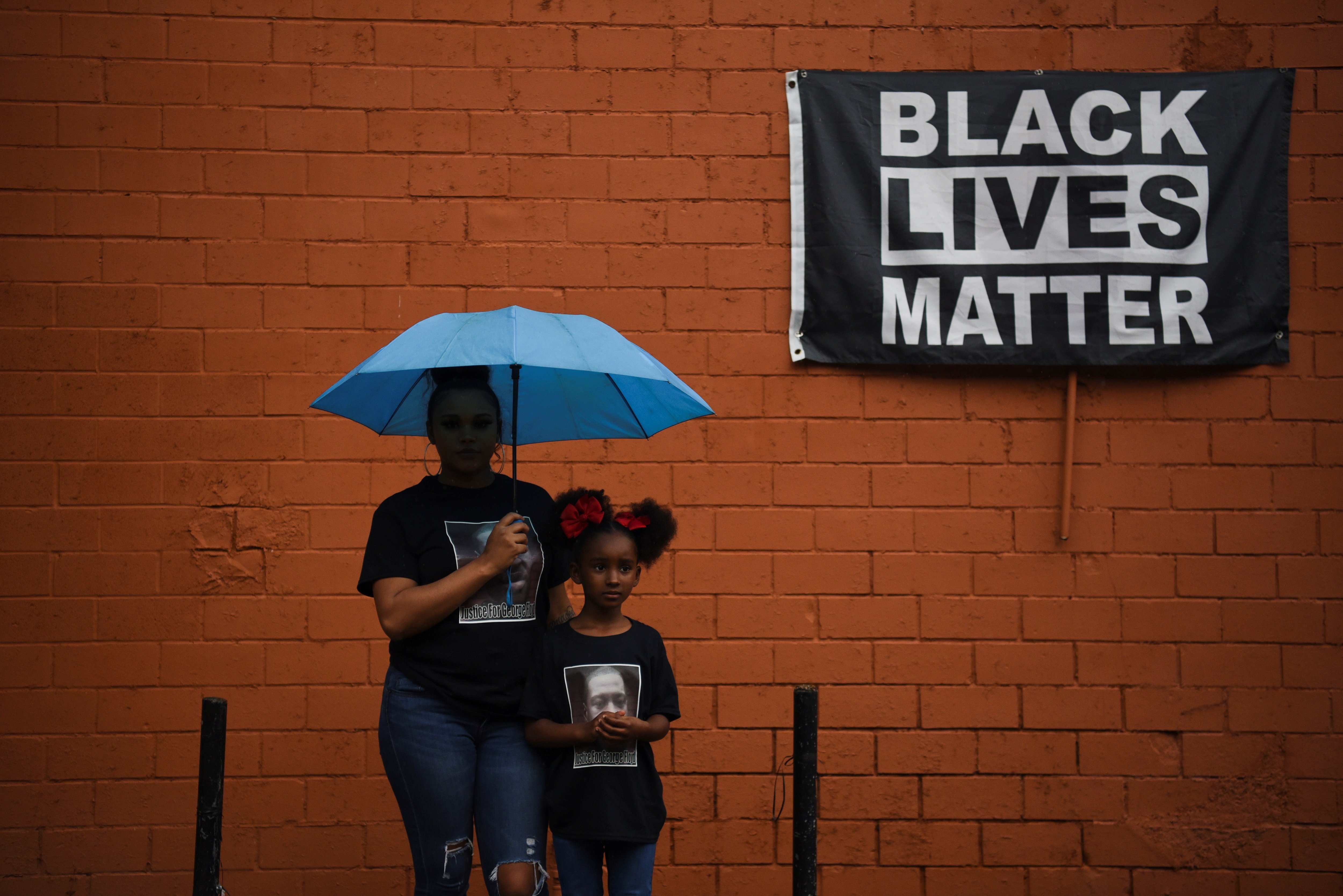 Brittany Elmore of Houston poses for a photo with her daughter Brooklyn near a "Black Lives Matter" sign May 23. (CNS)