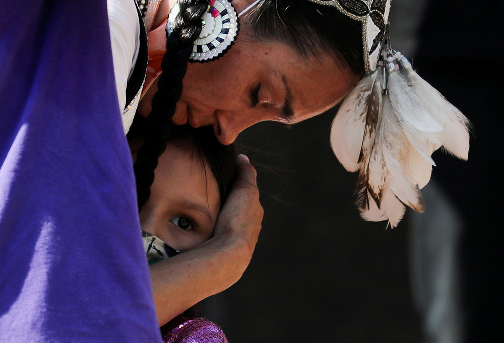 A woman embraces her daughter during a rally at the former Kamloops Indian Residential School in Kamloops, British Columbia, June 6. (CNS/Reuters/Chris Helgren)