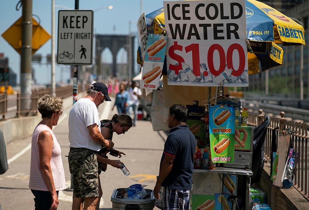 People on the Brooklyn Bridge in New York City buy cold water during a heat wave June 30. (CNS/Reuters/Eduardo Munoz)