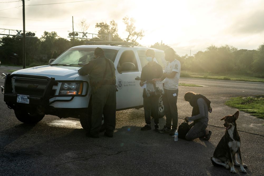 Migrants from Central America are processed July 8 by a Border Patrol agent in Penitas, Texas, after crossing the Rio Grande. (CNS photo/Go Nakamura, Reuters) 