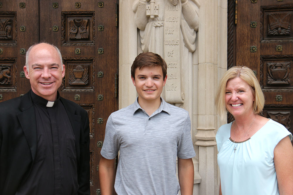 Anthony Schena, a senior at De La Salle Collegiate High School in Warren, Michigan, is pictured June 8 with Fr. J.J. Mech and Christine Broses, rector and pastoral associate of the Cathedral of the Most Blessed Sacrament. (CNS/Detroit Catholic/Dan Meloy)