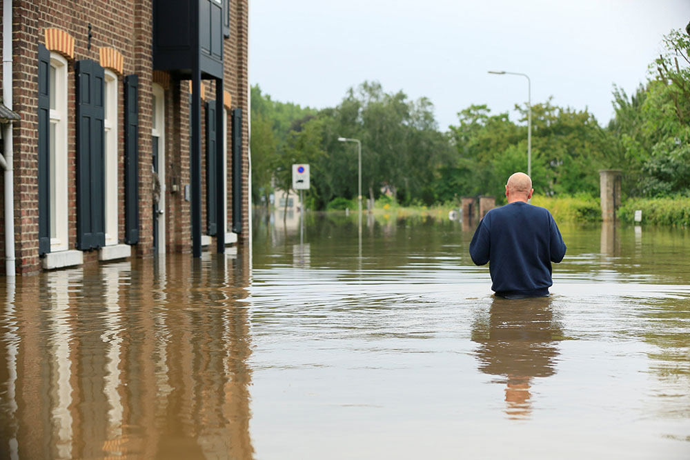 A person wades through floodwaters in Guelle, Netherlands, July 16. A record rainfall caused dams to burst and rivers to overflow into towns and streets across western Germany, Belgium, as well as parts of the Netherlands, Switzerland and northern France.