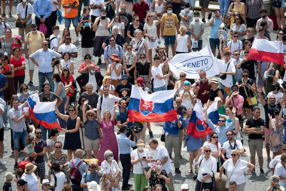 Pilgrims holding the Slovak flag cheer in St. Peter's Square at the Vatican July 4 as Pope Francis announces he will visit their country Sept. 12-15. (CNS/Vatican Media) 