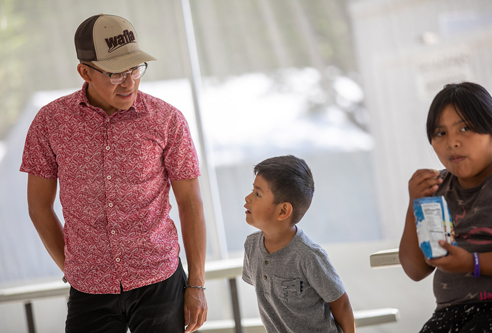 Daniel Sanchez, a seminarian with the Diocese of Yakima, Washington, checks in with migrant children during a visit from the Literacy Wagon July 29, 2021.