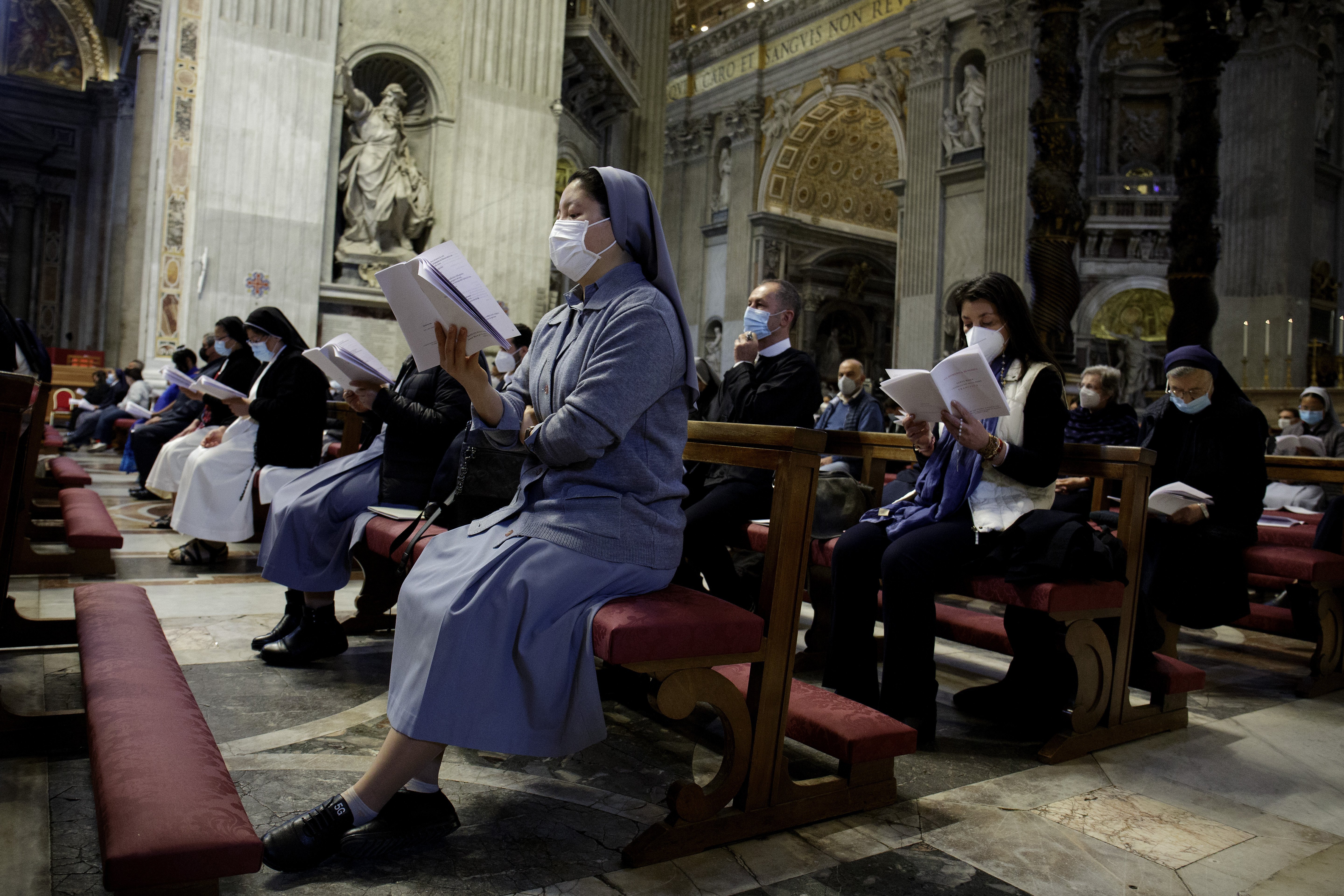 People wear protective masks as Pope Francis celebrates a Mass in St. Peter's Basilica at the Vatican May 16, 2021. Italy is requiring proof of vaccination to enter a variety of indoor areas, including restaurants and movie theaters, but the Italian bisho