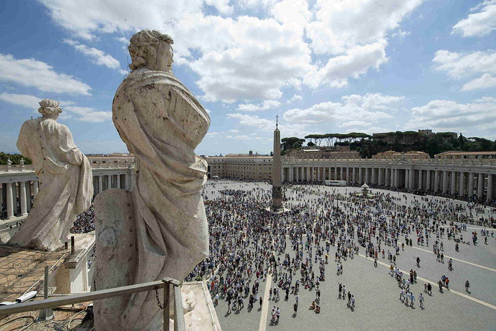 The crowd watches as Pope Francis leads the Angelus message from the window of his studio overlooking St. Peter's Square at the Vatican Aug. 8. In his Angelus message, the pope said Jesus is the "essential bread of life."