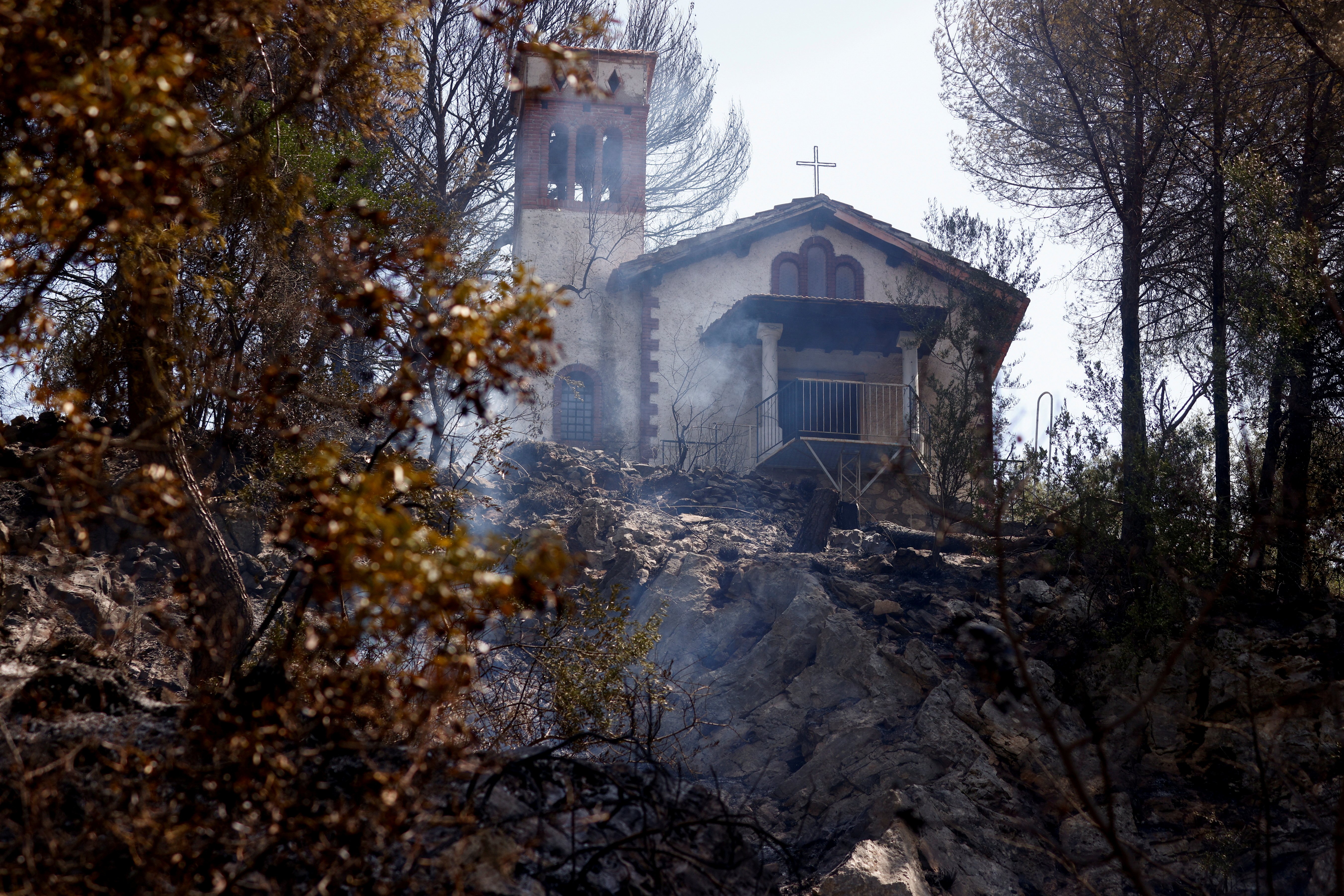 Burned vegetation is pictured near a church at the Monte Catillo nature reserve in Tivoli, Italy, Aug. 13, 2021. Locals were evacuated from small communities near Rome when a wildfire broke out as the Italian capital faced temperatures of around 99 degree
