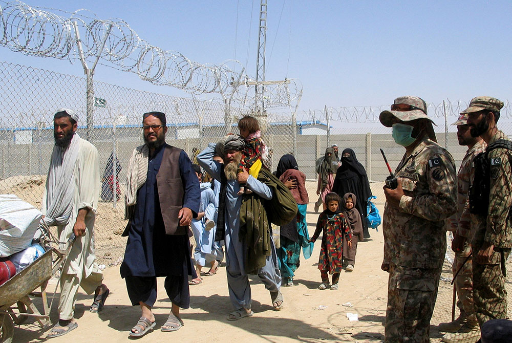 People arriving from Afghanistan at the Pakistan-Afghanistan border town of Chaman Aug. 19 People arriving from Afghanistan make their way through the Friendship Gate crossing point Aug. 19 at the Pakistan-Afghanistan border town of Chaman, Pakistan. (CNS/Saeed Ali Achakzai, Reuters)