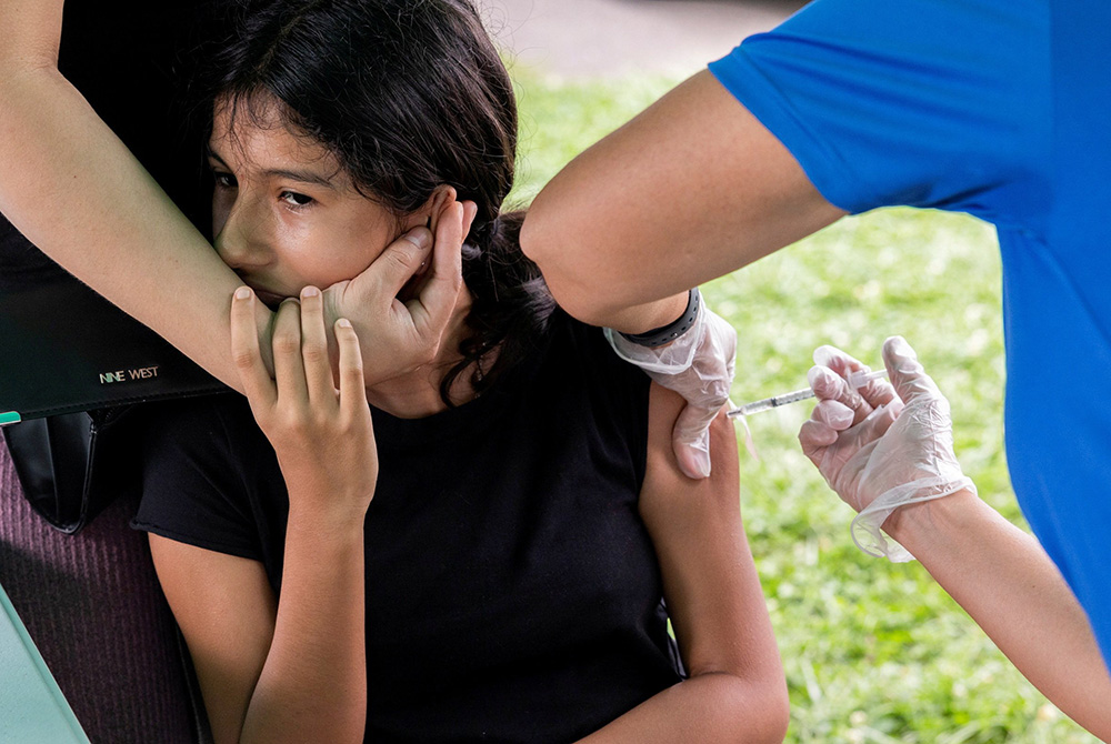 A young person in Bensalem, Pennsylvania, receives the coronavirus vaccine Aug. 22, during an outreach campaign for the Latino community. (CNS/Reuters/Rachel Wisniewski)