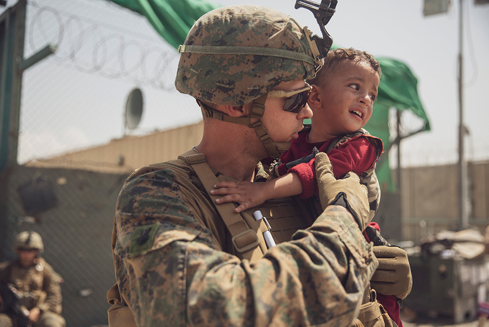 A U.S. Marine calms a toddler during an evacuation at Hamid Karzai International Airport Aug. 22 in Kabul, Afghanistan. (CNS/U.S. Marine Staff Sgt. Victor Mancilla, handout via Reuters)