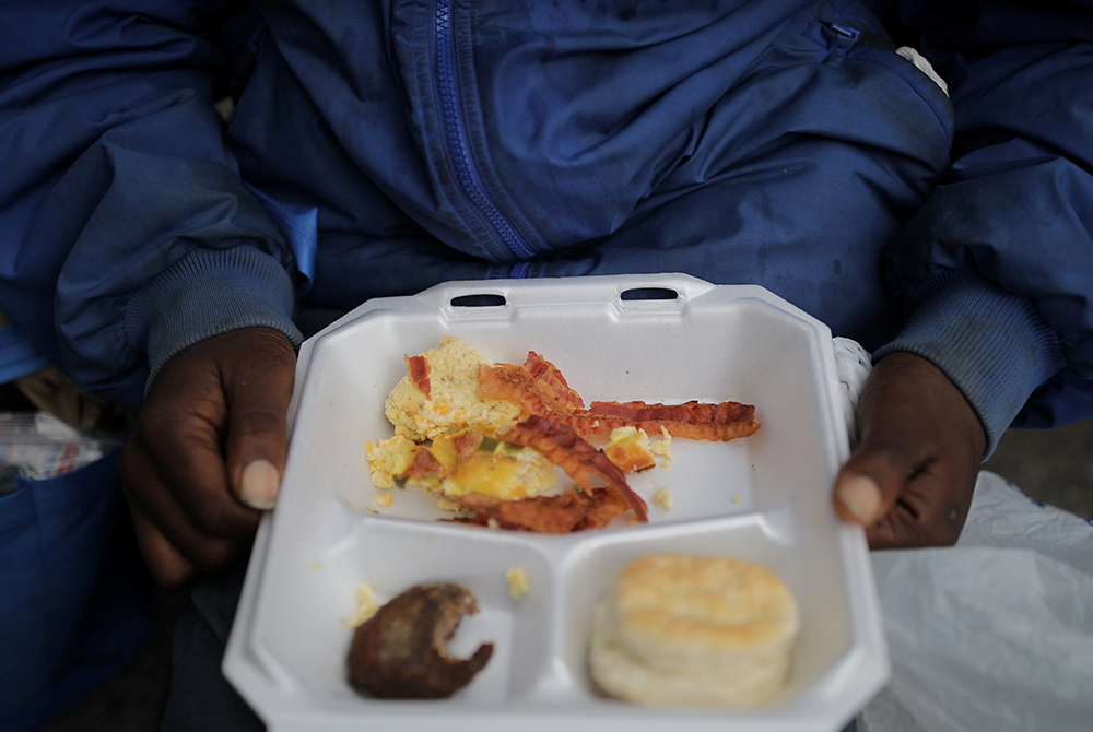 A homeless person in Birmingham, Alabama, eats breakfast during the distribution of food and clothes April 18, 2020. (CNS/Reuters/Carlos Barria) A homeless person in Birmingham, Alabama, eats breakfast during the distribution of food and clothes April 18, 2020. (CNS/Reuters/Carlos Barria)