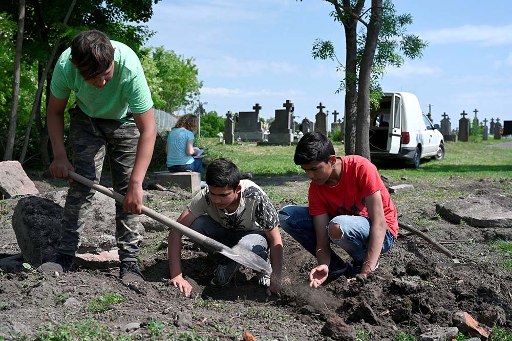 Boys from the Roma community work to restore a forgotten Jewish cemetery in the village of Vinodol, Slovakia, June 5. Pope Francis plans to meet with Jewish leaders in Bratislava Sept. 12. (CNS/Reuters/Radovan Stoklasa)