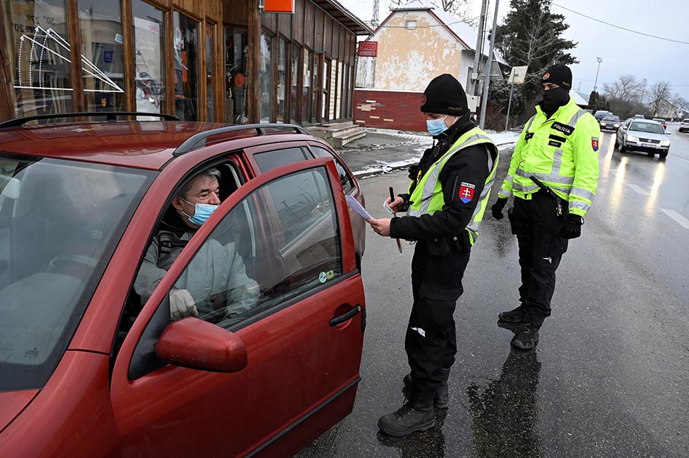 A police officer checks the negative COVID-19 test certificate of a person inside a car in Trencin, Slovakia, Jan 27. For Pope Francis' visit Hungary and Slovakia Sept. 12-15, realities of the pandemic pose challenges.