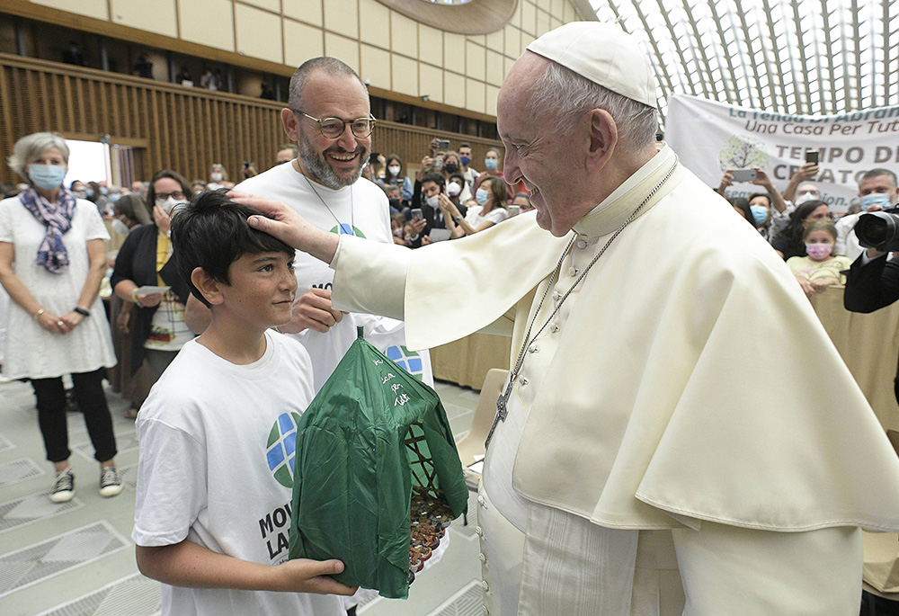 Pope Francis accepts the gift of a handmade "Abraham's tent" from a boy during his general audience in the Paul VI hall at the Vatican Sept. 1, 2021. The gift was given by members of the Laudato Si' Movement. (CNS/Vatican Media)