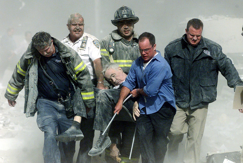 New York firefighters and rescue workers are seen Sept. 11, 2001, carrying Franciscan Fr. Mychal Judge, a chaplain with the New York Fire Department, who died in the aftermath of the attacks on the World Trade Center. (CNS/Reuters/Shannon Stapleton)