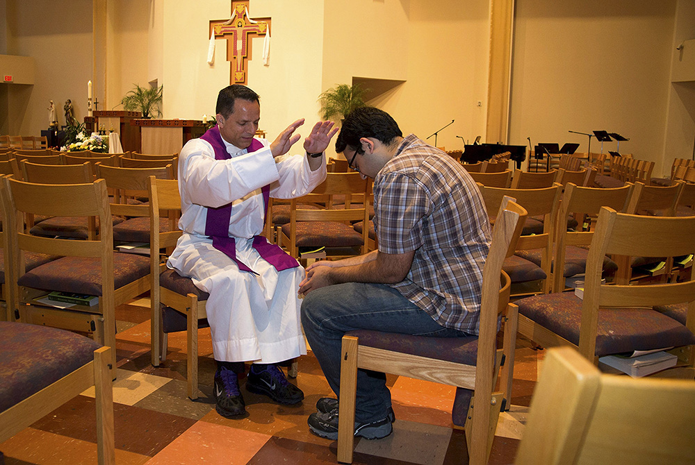 A priest blesses a student In this 2015 file photo, a priest blesses a student involved with the Fellowship of Catholic University Students at a church on the campus of the University of Texas at Austin at the University Catholic Center. (CNS/Courtesy of FOCUS)