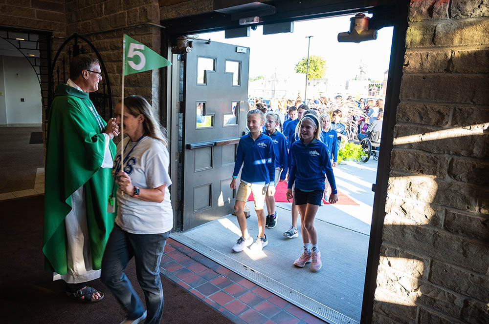 Fr. Ron Belitz, pastor of St. John Nepomucene Parish in Little Chute, Wisconsin, greets fifth graders from St. John Nepomucene School Sept. 10, 2021, as they enter the church for the first all-school Mass.