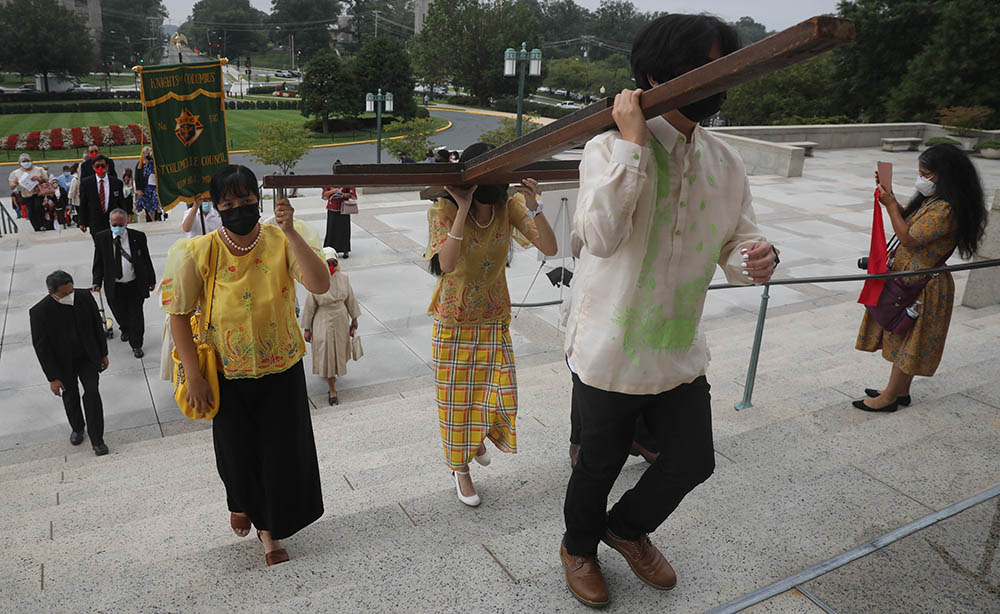 Filipino Catholics carry a cross into the Basilica of the National Shrine of the Immaculate Conception in Washington Sept. 18, for a Mass marking the 500th anniversary of Christianity in the Philippines. (CNS/Catholic Standard/Andrew Biraj)
