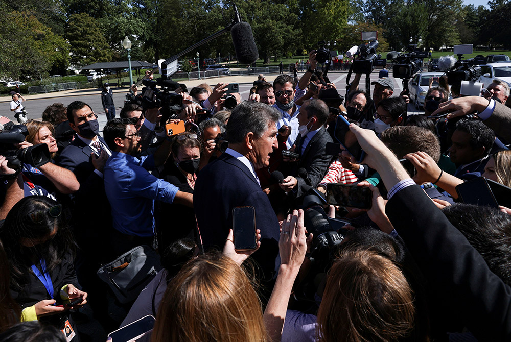 Sen. Joe Manchin, D-W.Va., makes his way through a crowd of Capitol Hill reporters outside the U.S. Capitol Sept. 30 in Washington. (CNS /Reuters/Leah Millis)