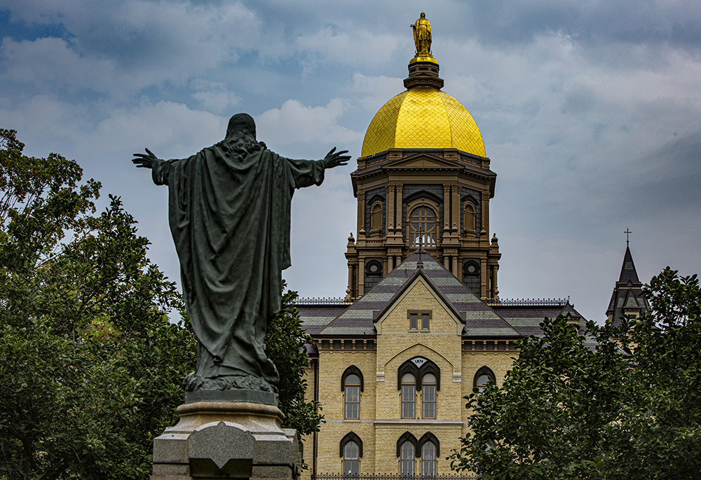 A statue of Jesus facing the Golden Dome with its statue of Mary atop the administration building of the University of Notre Dame is seen Aug. 6 in Notre Dame, Indiana. (CNS/Chaz Muth)