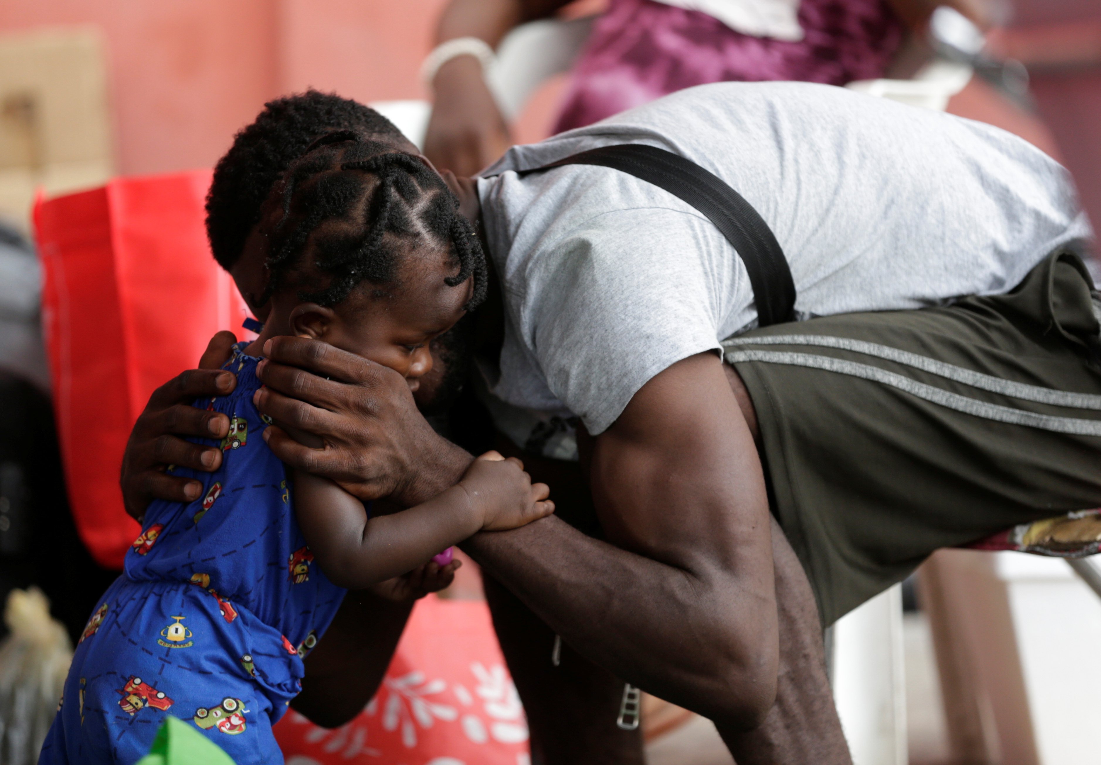 A Haitian migrant seeking refuge in the U.S., hugs his daughter outside a shelter in Monterrey, Mexico, Sept. 28, 2021. (CNS photo/Daniel Becerril, Reuters)