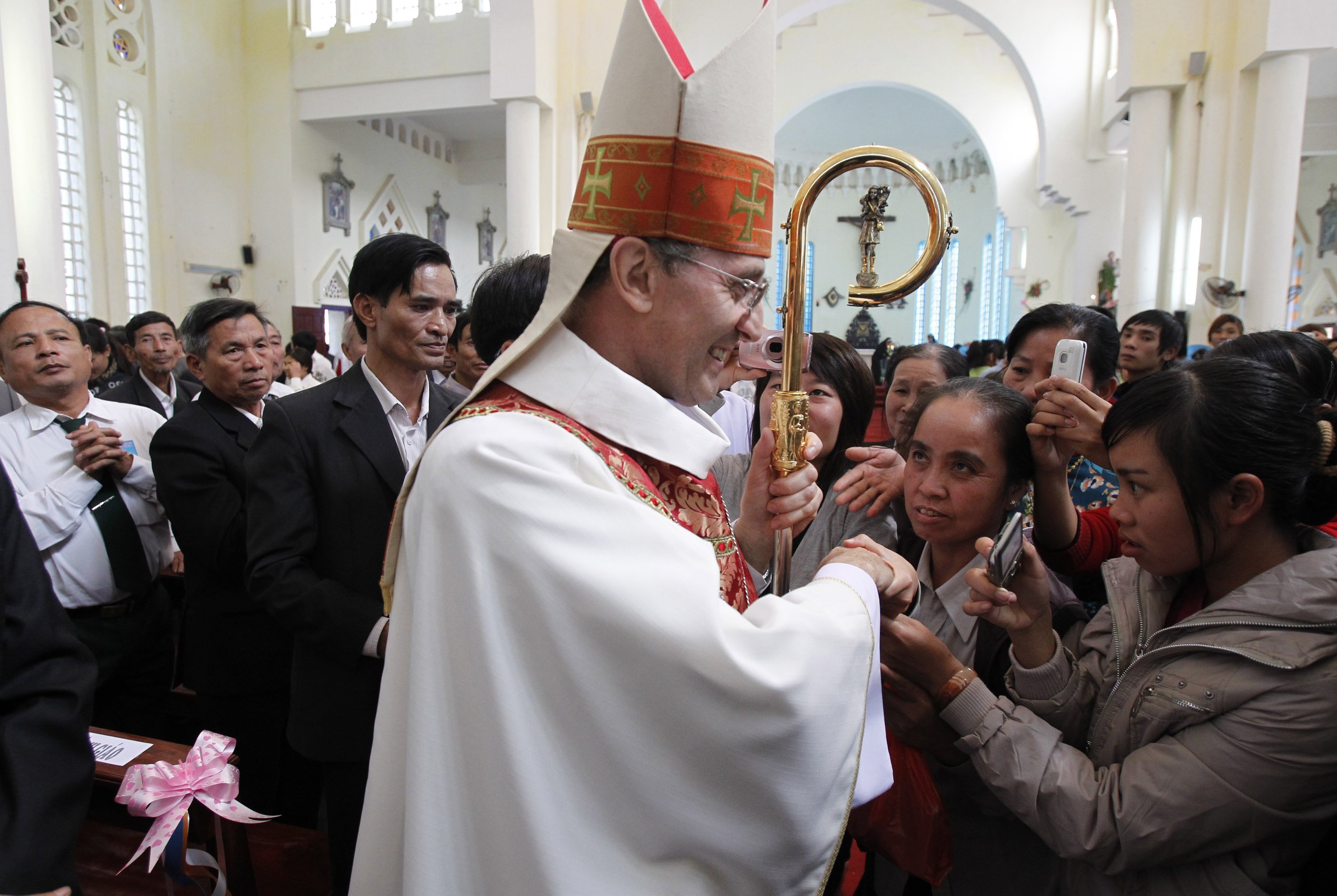 Archbishop Leopoldo Girelli, then nonresident pontifical representative for Vietnam, is greeted by people after Mass at St. Teresa Cathedral in Son Tay, Vietnam, in this Nov. 25, 2011. (CNS photo/Kham, Reuters)